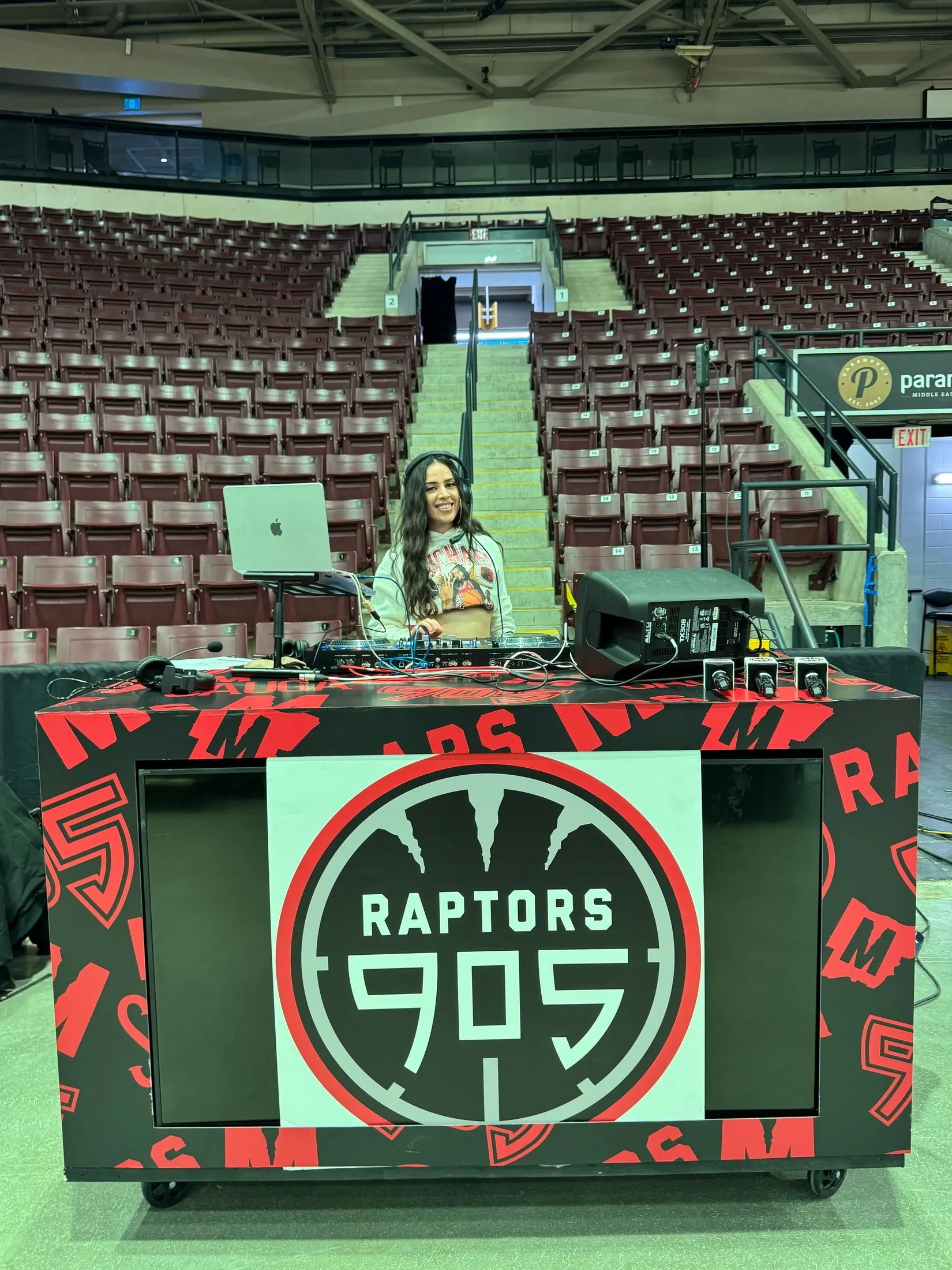 DEEJAY T-JR. behind the Raptors 905 branded DJ booth on the arena floor at Paramount Fine Foods Centre.
